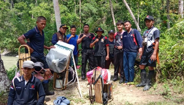 Dua Personel Polres Banggai Bersama Rekan – Rekan Panwas, Kpps, dan Pps Terobos Sungai Kawal Logistik Pilkada 2024 ke Desa Dolom, Kecamatan Lobu